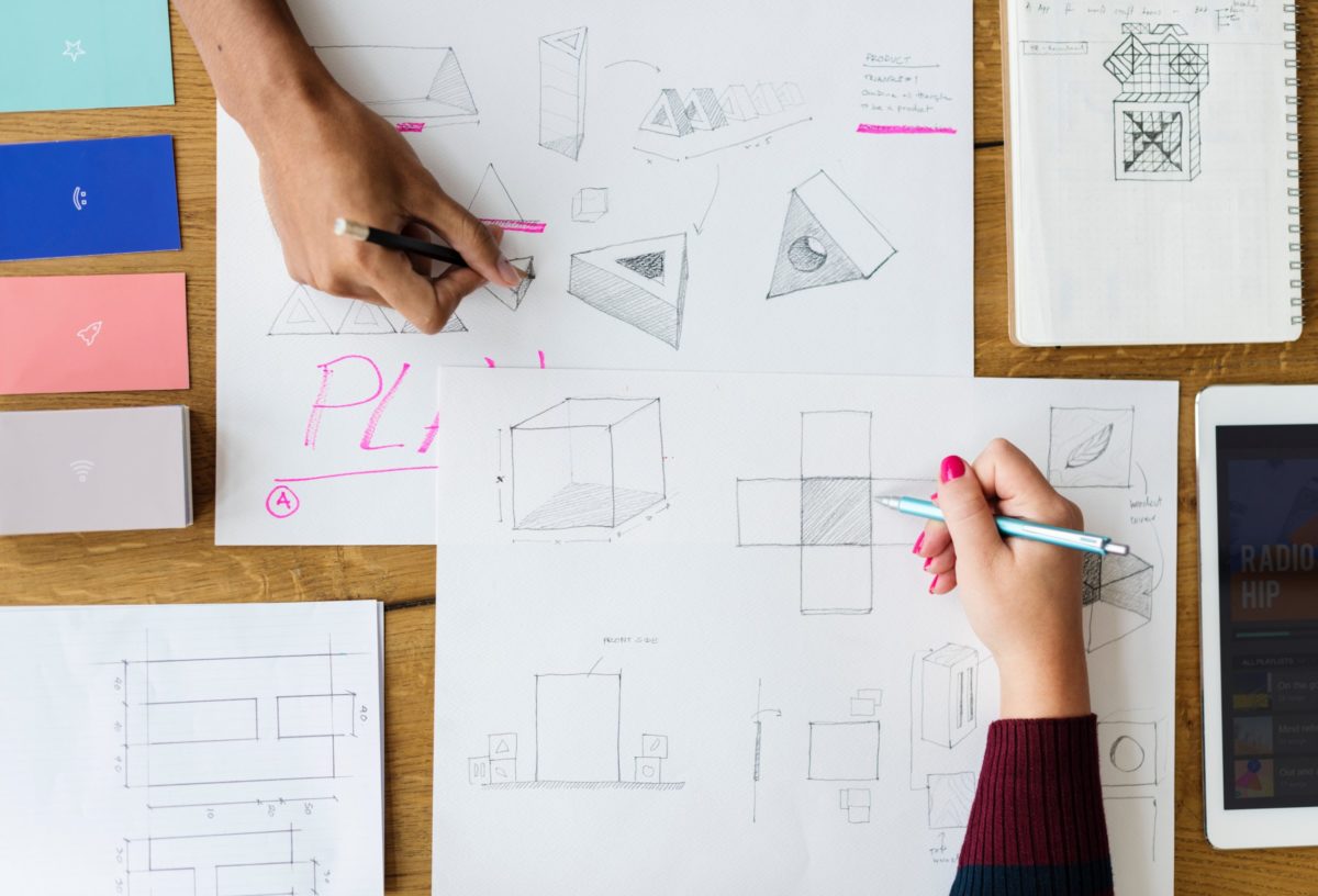 Hands drawing shapes on paper