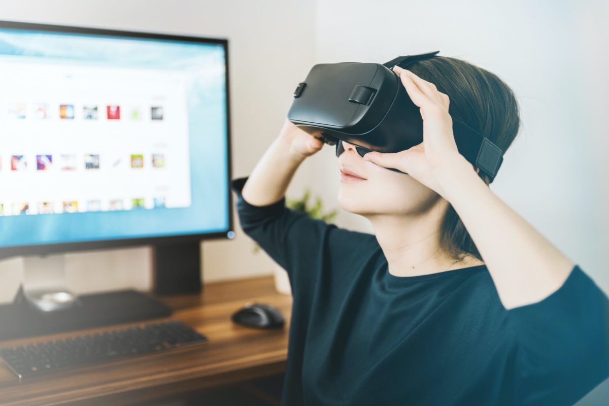 A worker in a VR headset at her desk