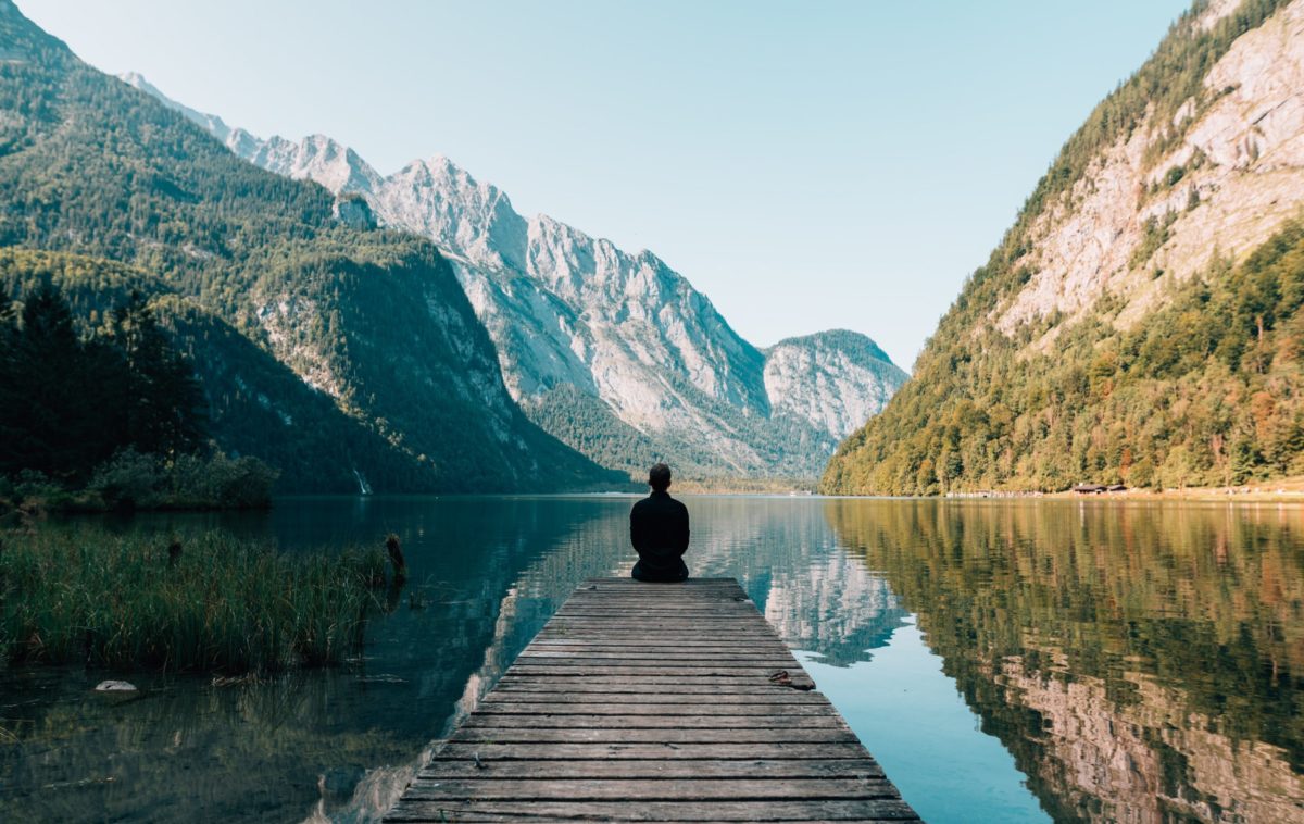 Someone sitting at the edge of a pier